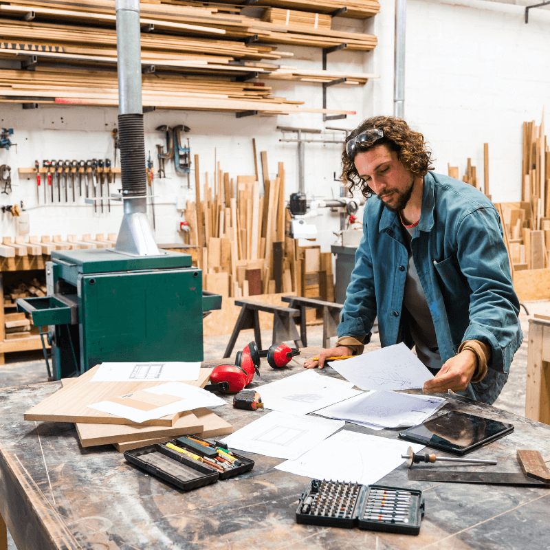 Young man sorting through paperwork in his workshop